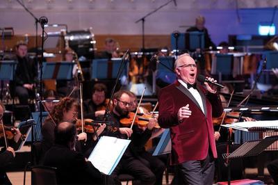 a man stands on stage with a microphone