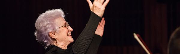 Woman holding arms in air conducting orchestra