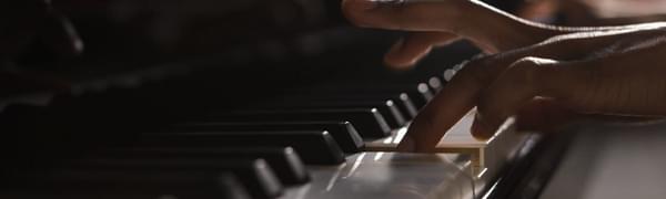 A person playing the piano focused on their hands