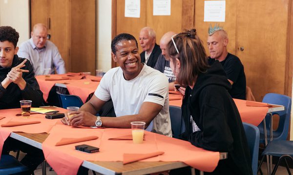People sat around tables talking and smiling