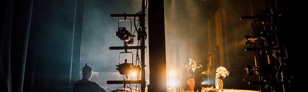 Photo from the side of the stage showing cast members on and off stage