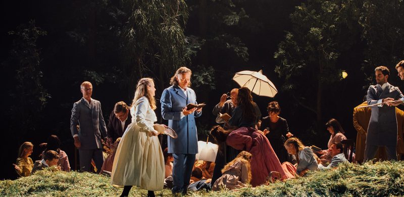 a group of people stand on a grassy stage