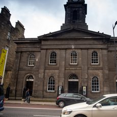 The brownstone exterior of Queen's Hall, with yellow Edinburgh International Festival banners either side
