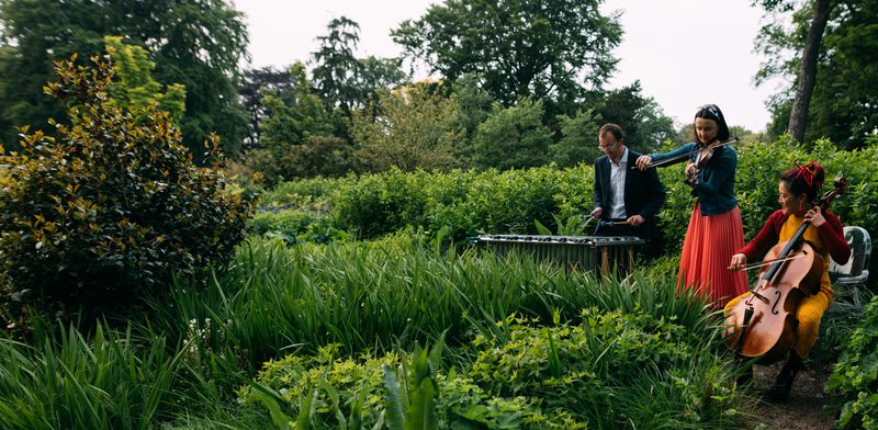 A trio of musicians performs in the Botanic Gardens in Edinburgh