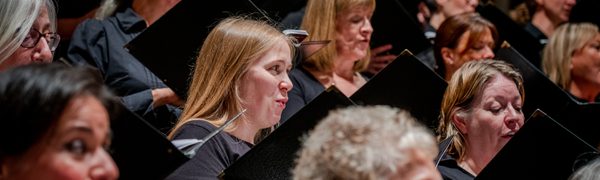 Women in the Edinburgh Festival Chorus pictured singing from sheet music