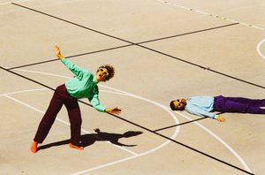 Merril Garbus and Nate Brenner of Tune Yards pose in a basketball court, wearing brightly coloured clothes