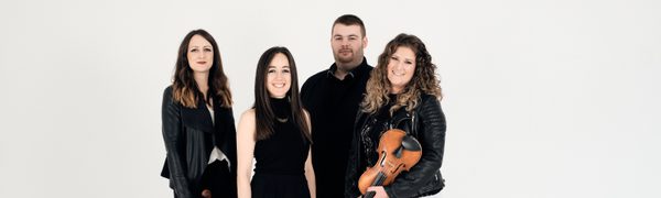 The four members of Fara pose together; three women with fiddles and one man, all dressed in black.