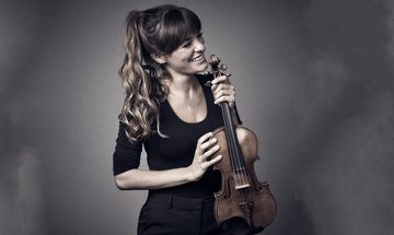 Nicola Benedetti smiles while holding her violin