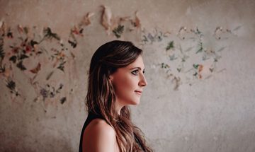 Siobhan Miller pictured in profile, standing in front of flowered wallpaper