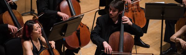 The string section of the Scottish Chamber Orchestra, with cello players in the foreground.