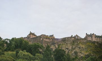 A view from below of Edinburgh Castle against a blue sky