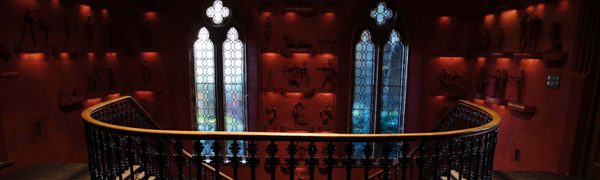 The stairs inside of The Hub, with large gothic windows and a double winding staircase