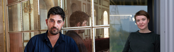 On the left, a man with short black hair and stubble leans against a vintage mirror and looks at the camera. On the right, a woman with short brown hair, in a dark green dress leans against a galvanised iron wall and looks directly at the camera.