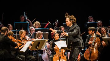 Maxim Emelyanychev stands in the centre of the Scottish Chamber Orchestra, dynamically conducting