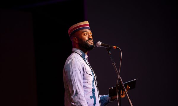 A man stands at a microphone ready to speak