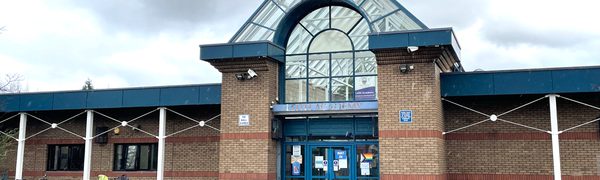 The front of Leith Academy, a one-storey brown brick building with a glass roof