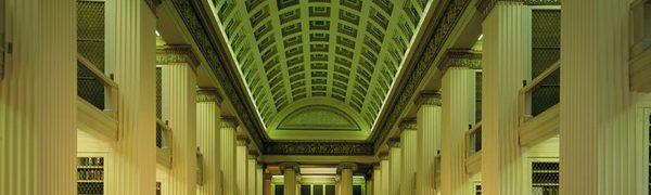 The interior of the Playfair Library, a neo-classical building with a long red carpet and painted ceiling, columns and statue busts