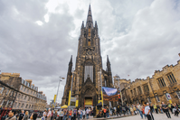 The front of The Hub, a neo-gothic church at the top of the Royal Mile, with many people walking in front of it