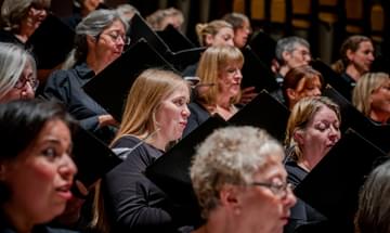 Women in the Edinburgh Festival Chorus pictured singing from sheet music