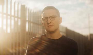 Sam Shepherd of Floating Points in a black t-shirt and glasses