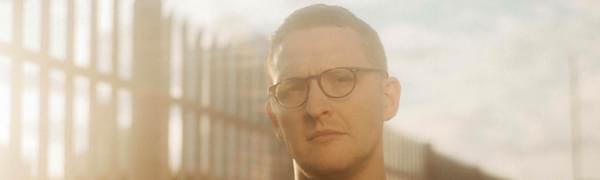 Sam Shepherd of Floating Points in a black t-shirt and glasses