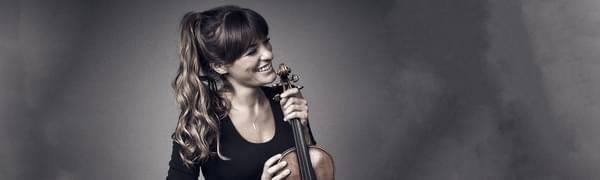 Nicola Benedetti smiles while holding her violin