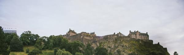 A view from below of Edinburgh Castle against a blue sky