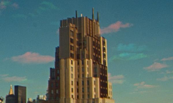 Grainy shot of a New York Building, plunging into the sky.