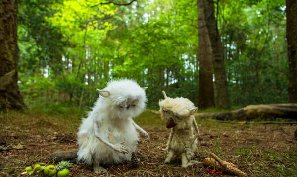 Two woodland creatures kneel together