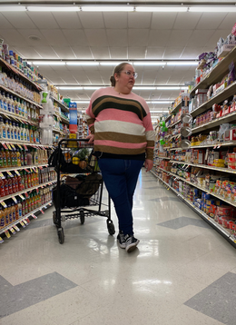 Aubrey Gordon stands by a trolley in a supermarket aisle