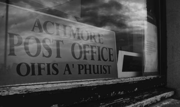 Black and white image of post office sign reflecting in the mirror