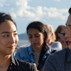 Greta Lee (Nora) and Teo Yoo (Hae Sung) sit on tour boat in Past Lives.