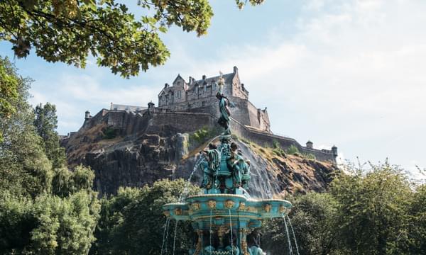 The view of Edinburgh Castle from Princes Street Gardens, with the fountain spraying water in the foreground