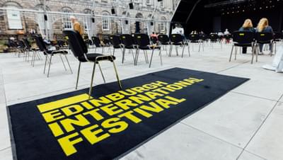 A welcome mat reads 'Edinburgh International Festival' at the entrance to the Old College Quad venue.