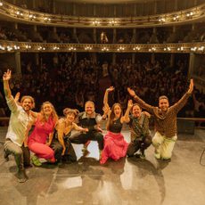 A group of people on stage, in a packed auditorium